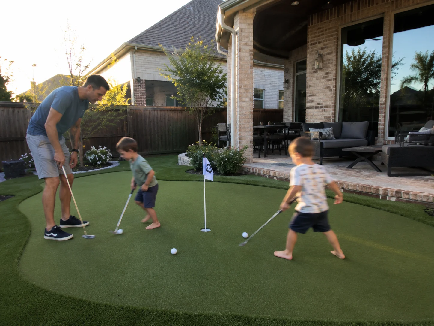 Family enjoying backyard putting green in McKinney TX by Medina Landscape